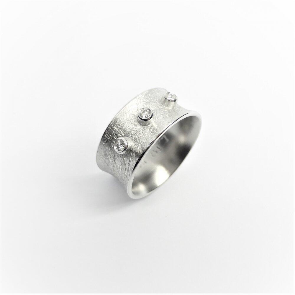 18k white gold ring with three diamonds.