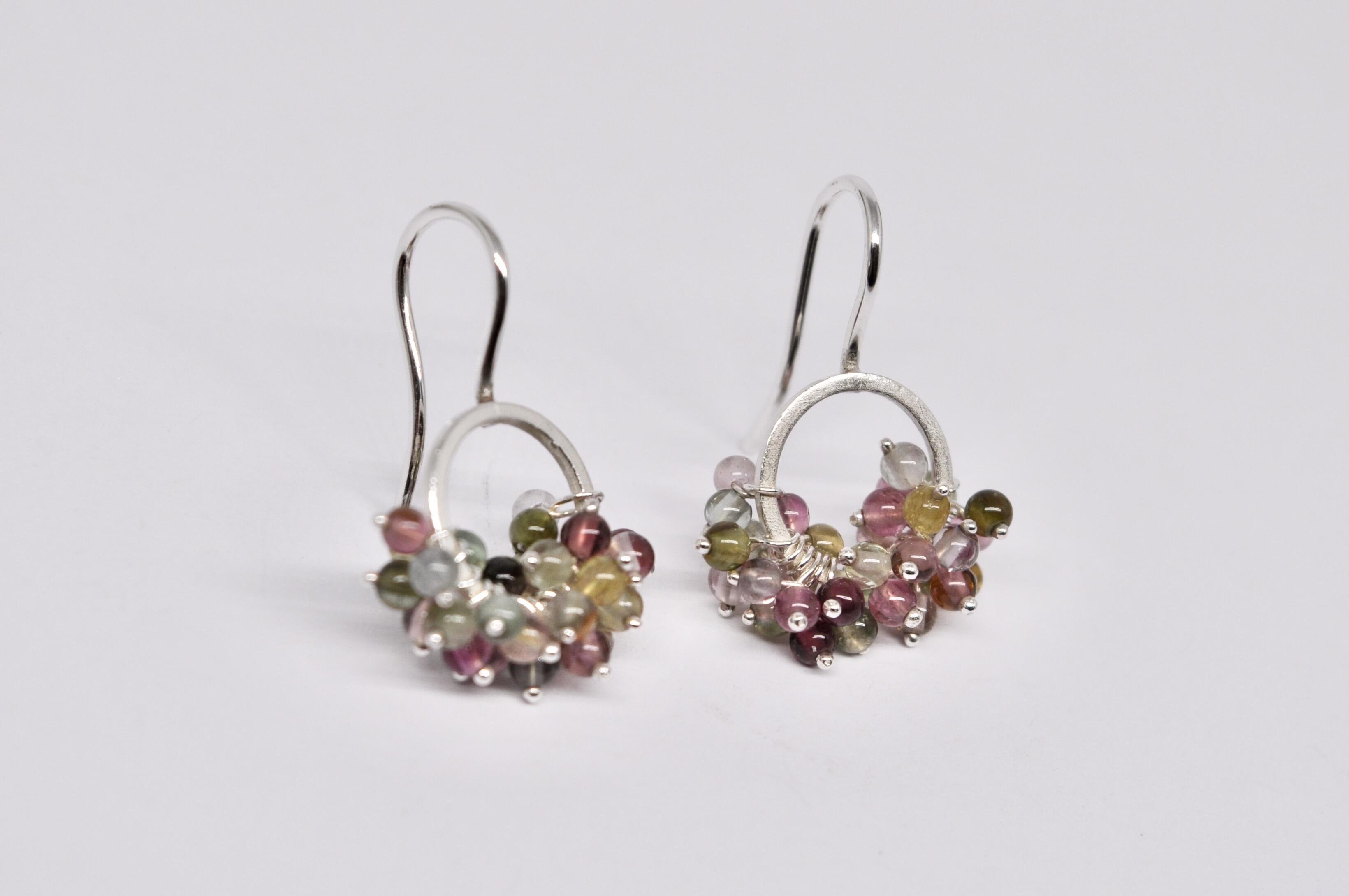 Boucles d'oreilles circulaires en argent avec un cluster de tourmalines multicolores.