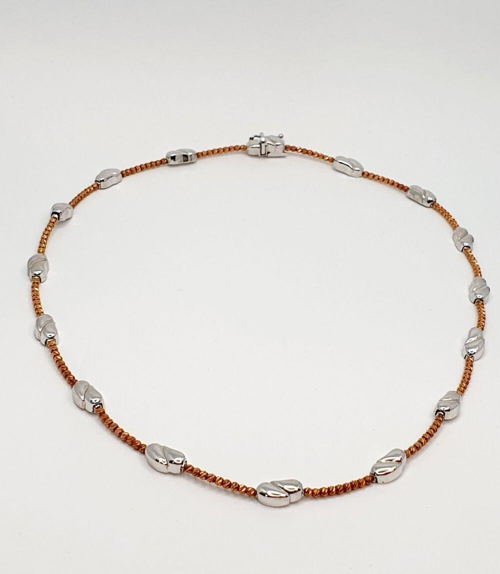 # Chaîne collier semi-rigide billes facettées or rose avec 2 virgules polies or blanc