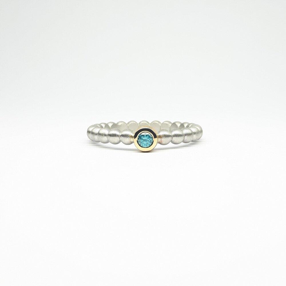 "round around", ball ring in 925 silver, 18kt yellow gold and blue zircon.