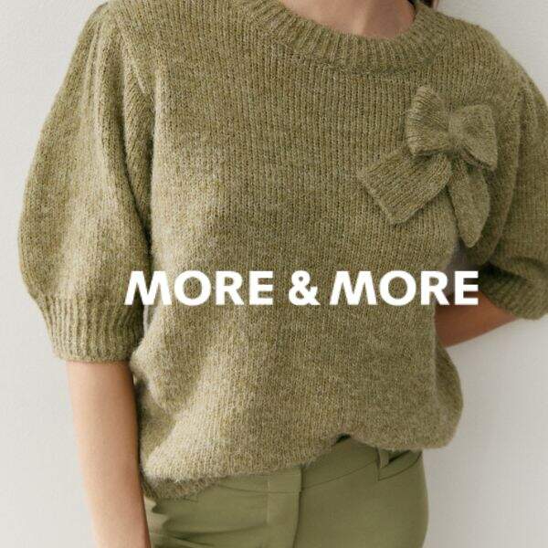 Grüner Strickpulli und das Markenlogo darüber